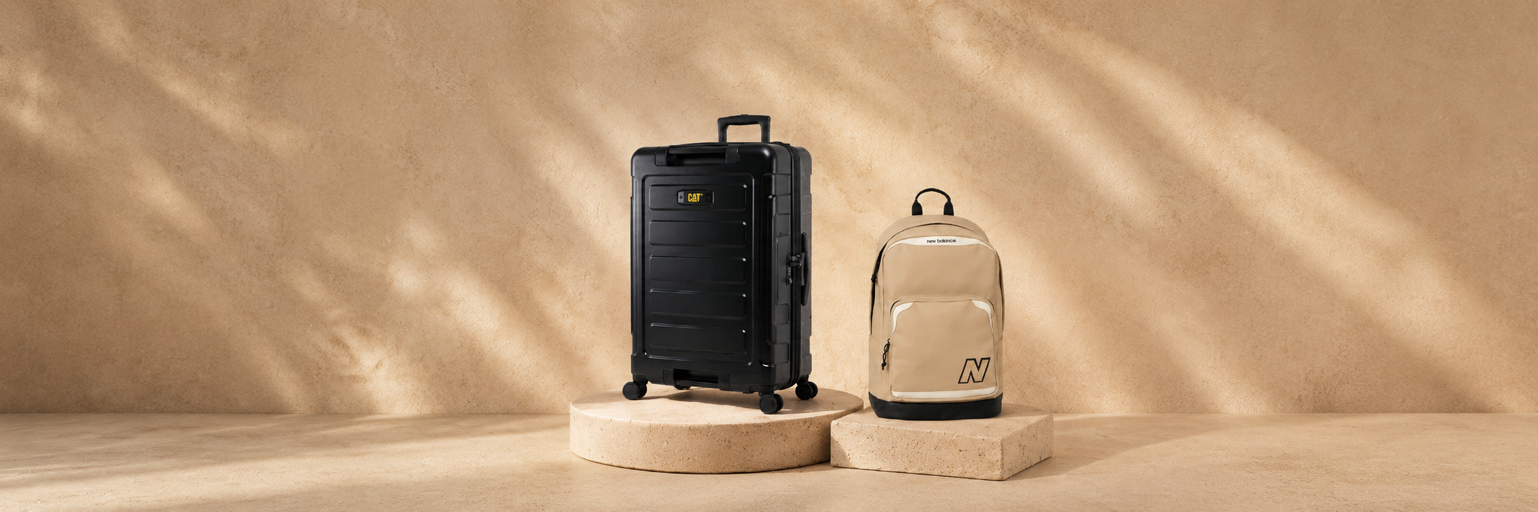 Curated travel bags and luggage arranged on a soft beige background for The Wola Bags & Travel collection